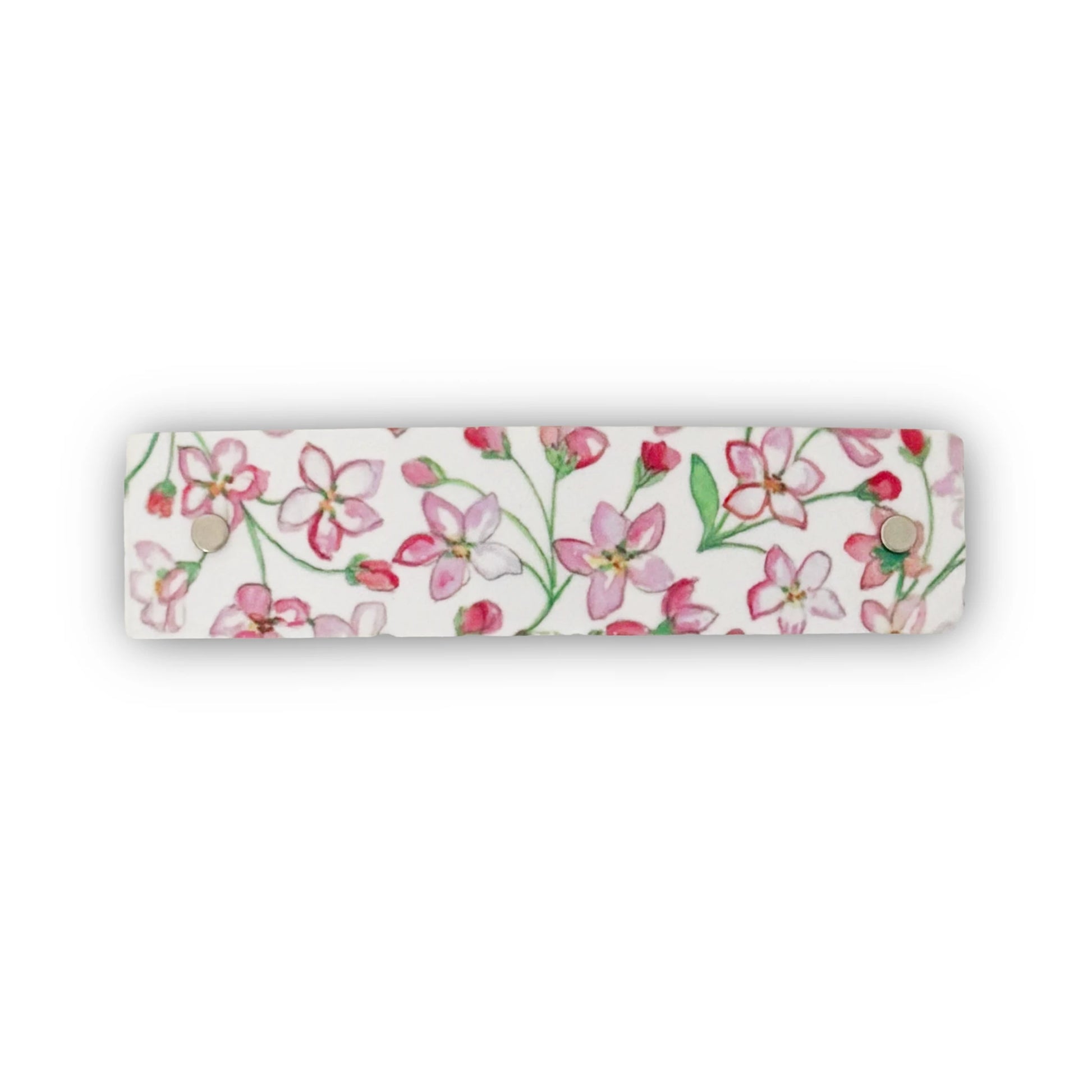 A handmade white metal hair clip, featuring a delicate original watercolor floral pattern of pink blossoms and green stems, shown against a plain white background.