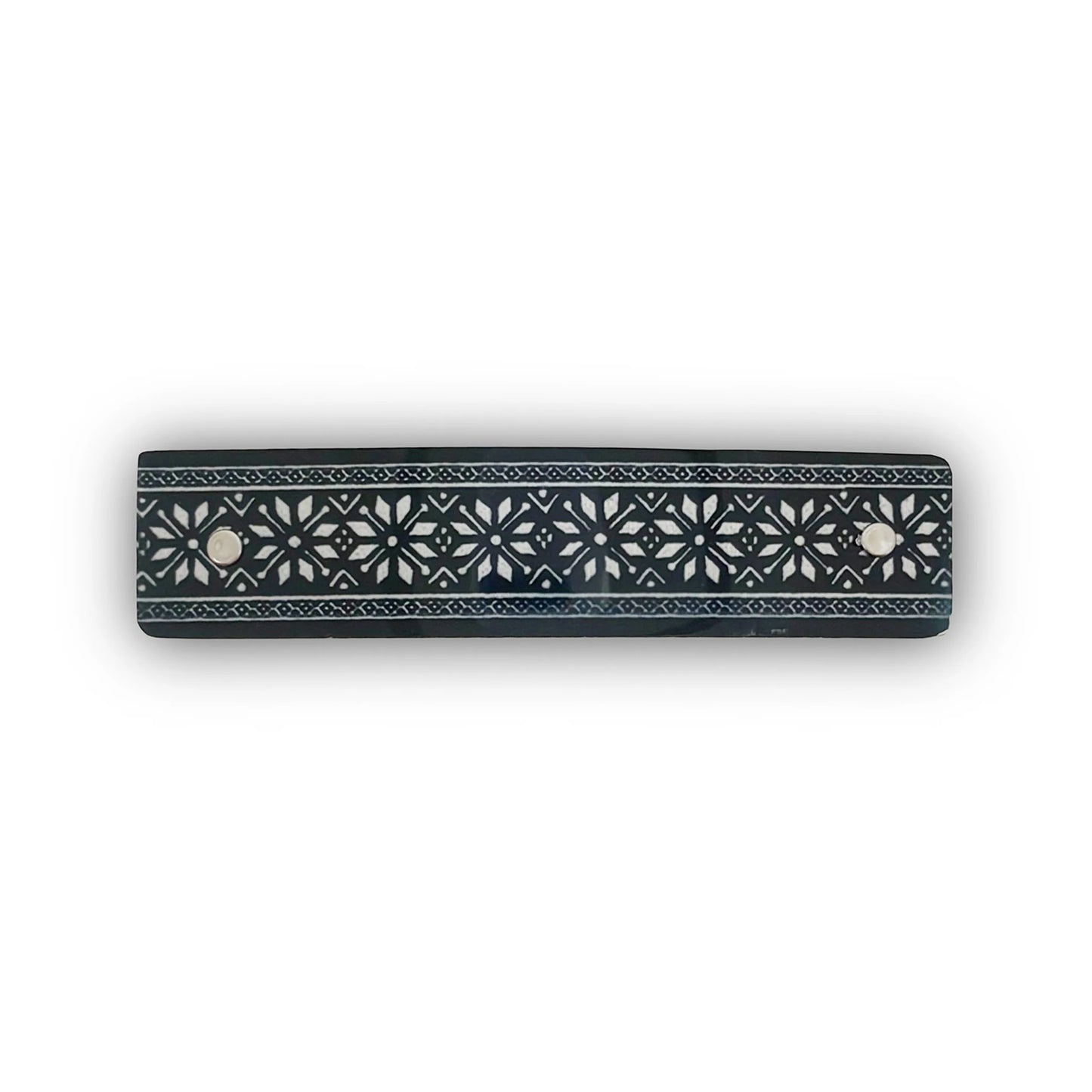 A hair barrette with a Nordic star design  in silver on black, handmade in North Carolin by Robbin V. Davis Studio.