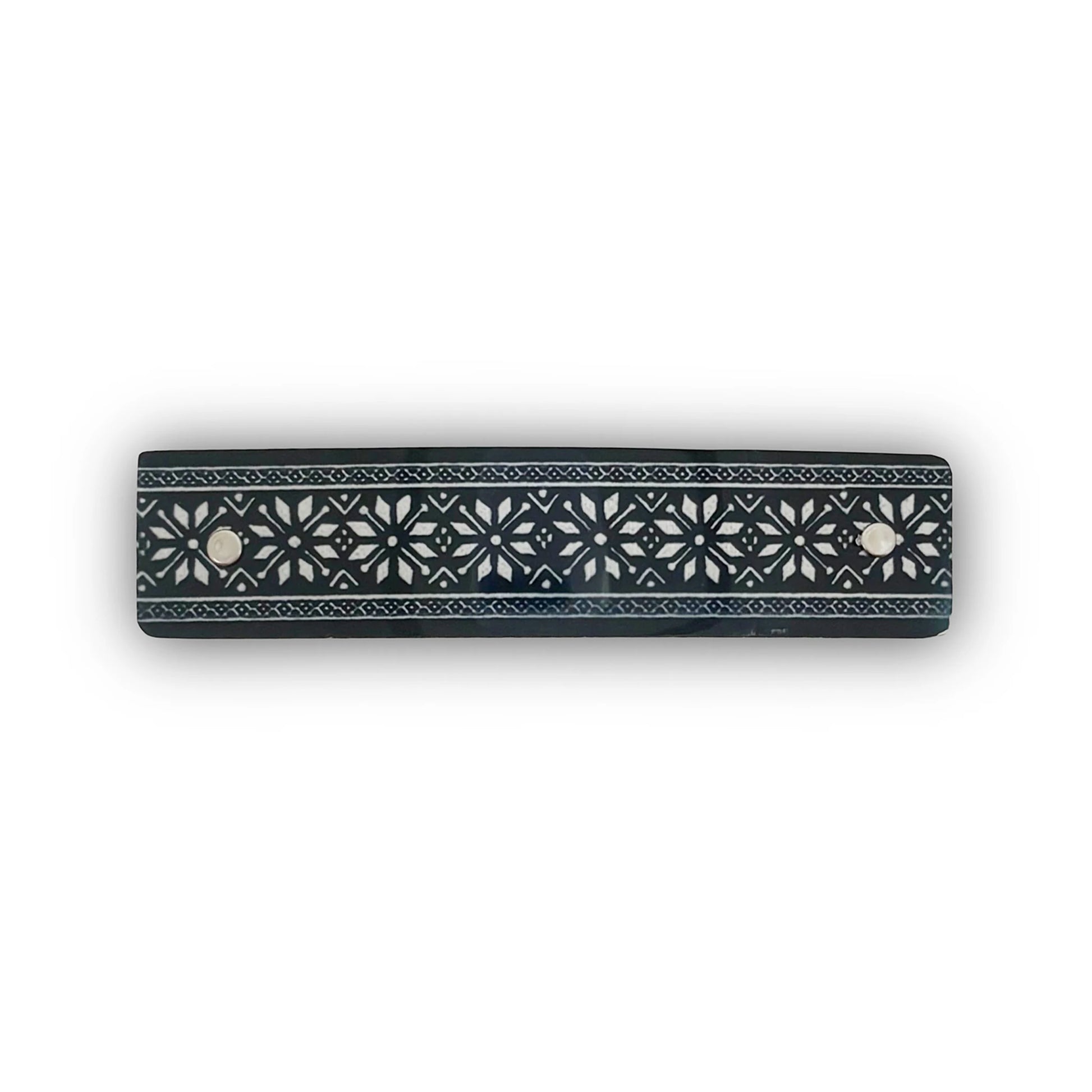 A hair barrette with a Nordic star design  in silver on black, handmade in North Carolin by Robbin V. Davis Studio.