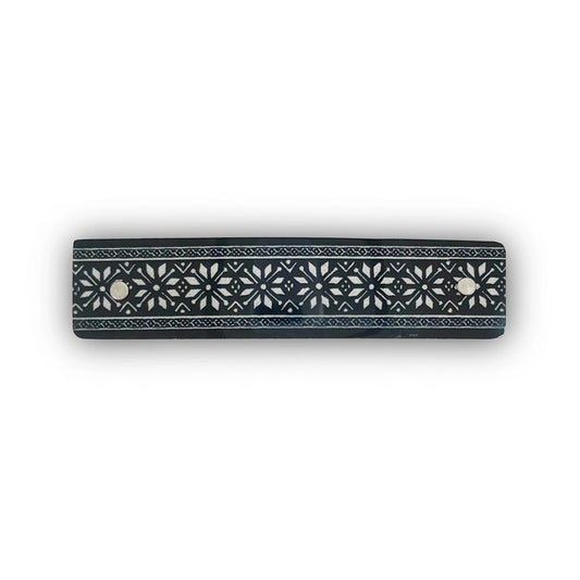 A hair barrette with a Nordic star design  in silver on black, handmade in North Carolin by Robbin V. Davis Studio.