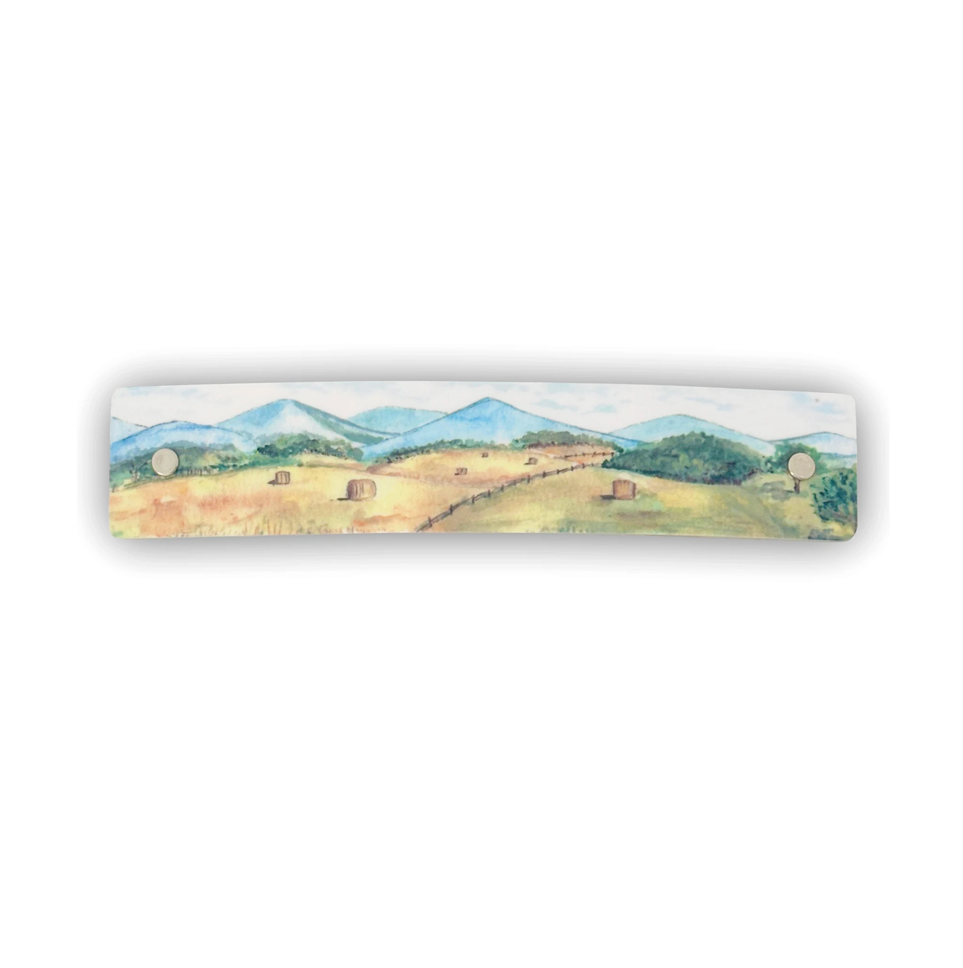 A rectangular boutique hair accessory featuring a watercolor landscape painting of a farm scene with hay rolls, trees, and mountains, shown against a plain white background.