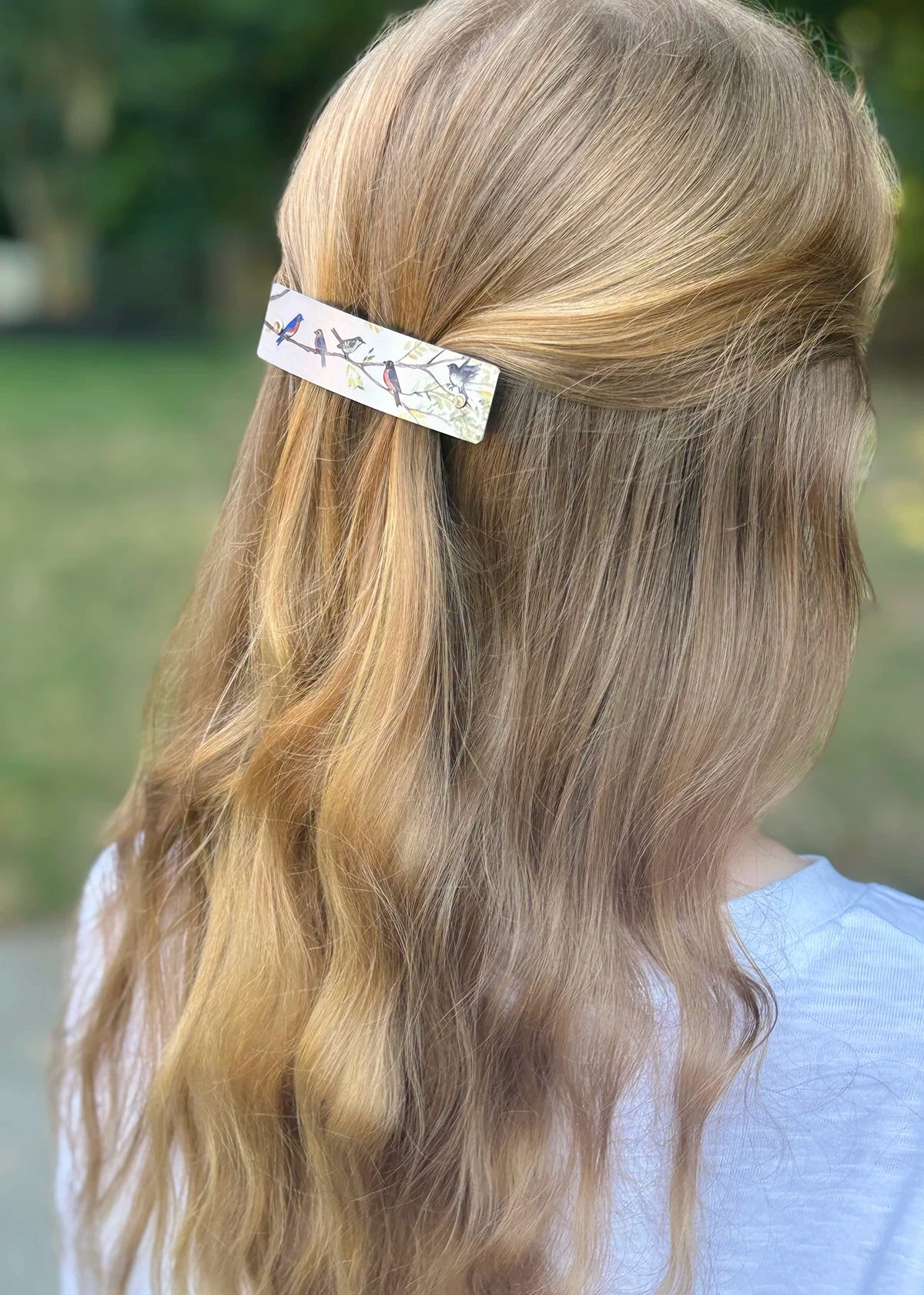 Birds on Branches artistic hair clip worn by a blond woman, modeled outside.