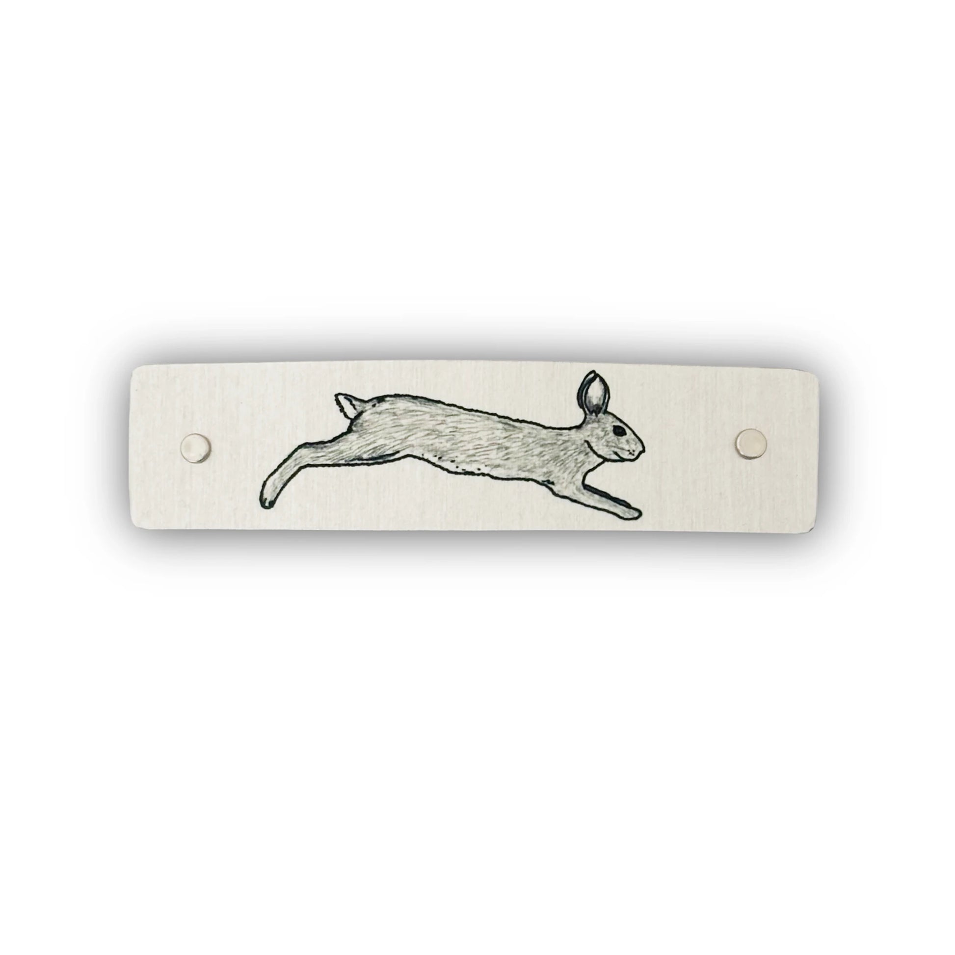 A rectangular brushed metal hair clip with a black line drawing of a leaping rabbit, shown on a plain white background.