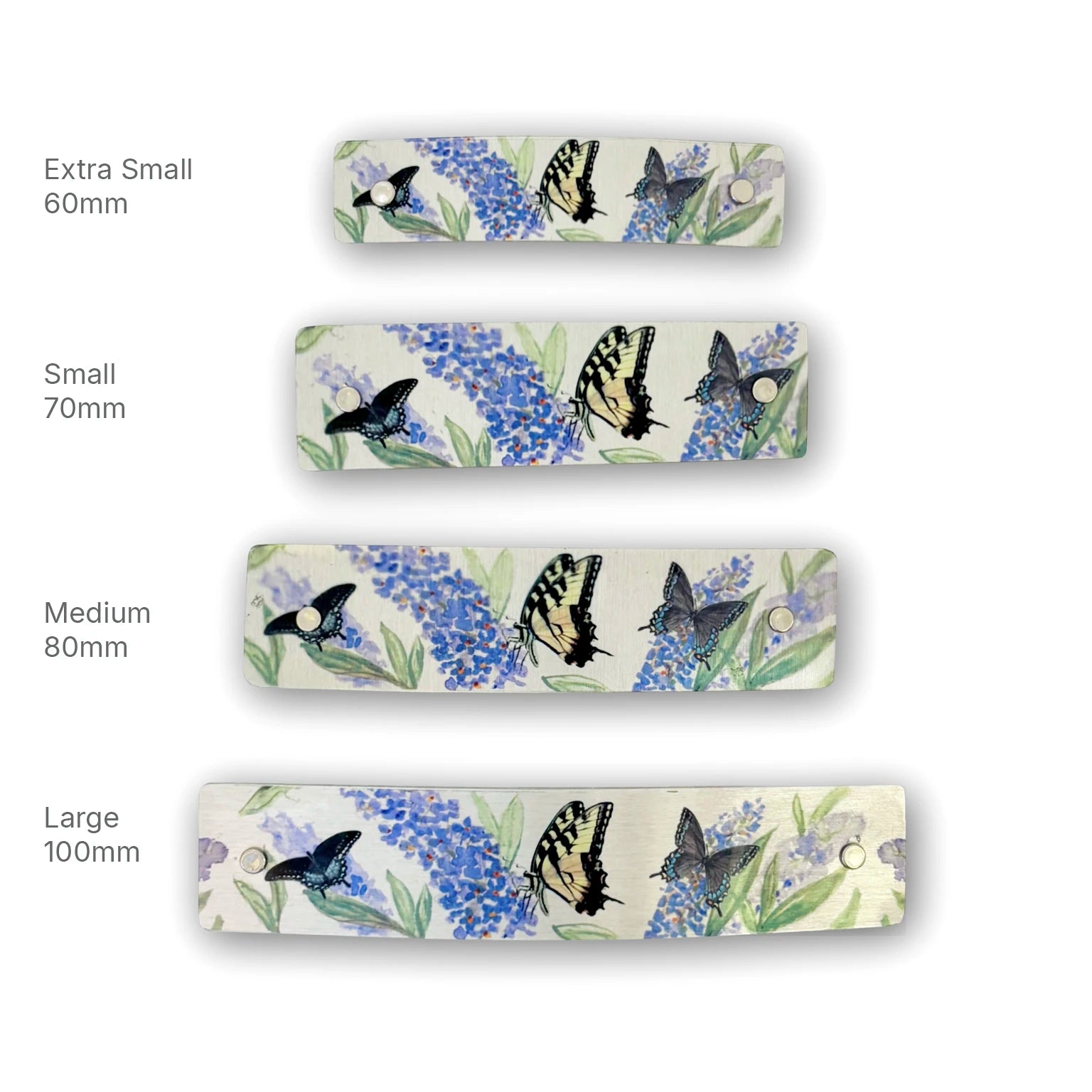 Four hair clips shown in different sizes (Extra Small 60mm, Small 70mm, Medium 80mm, Large 100mm) on a white background, each featuring a watercolor-style print of blue flowers and butterflies on a silver background.