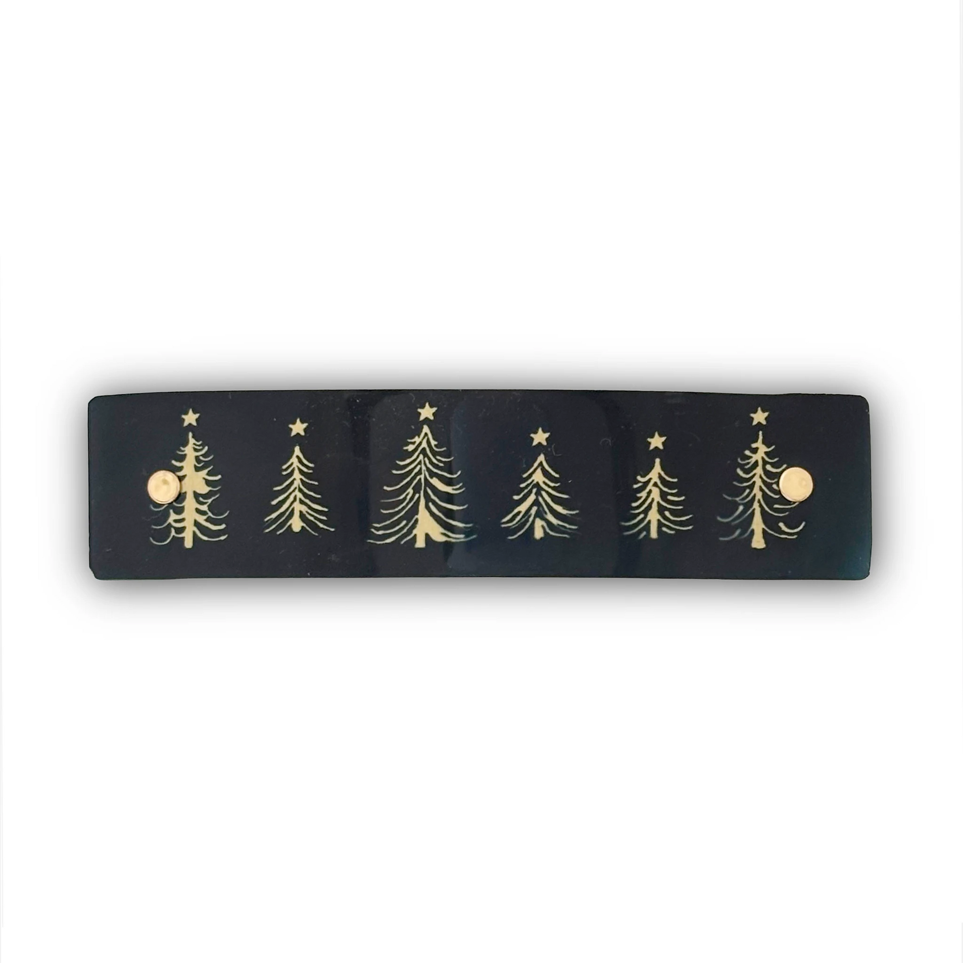A black rectangular hair clip featuring five whimsical gold Christmas tree designs with stars, shown against a plain white background.