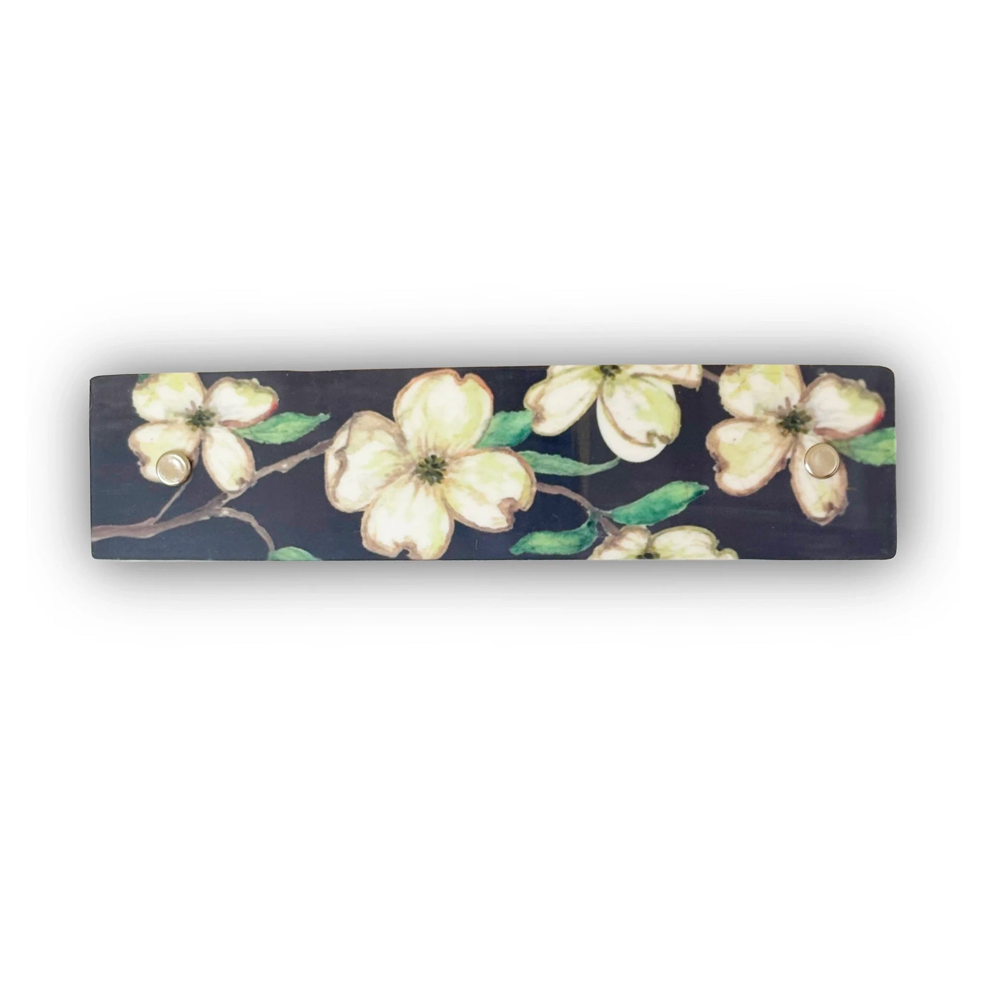 A rectangular hair barrette with a dark background featuring a painted floral pattern of white dogwood blossoms with green leaves.