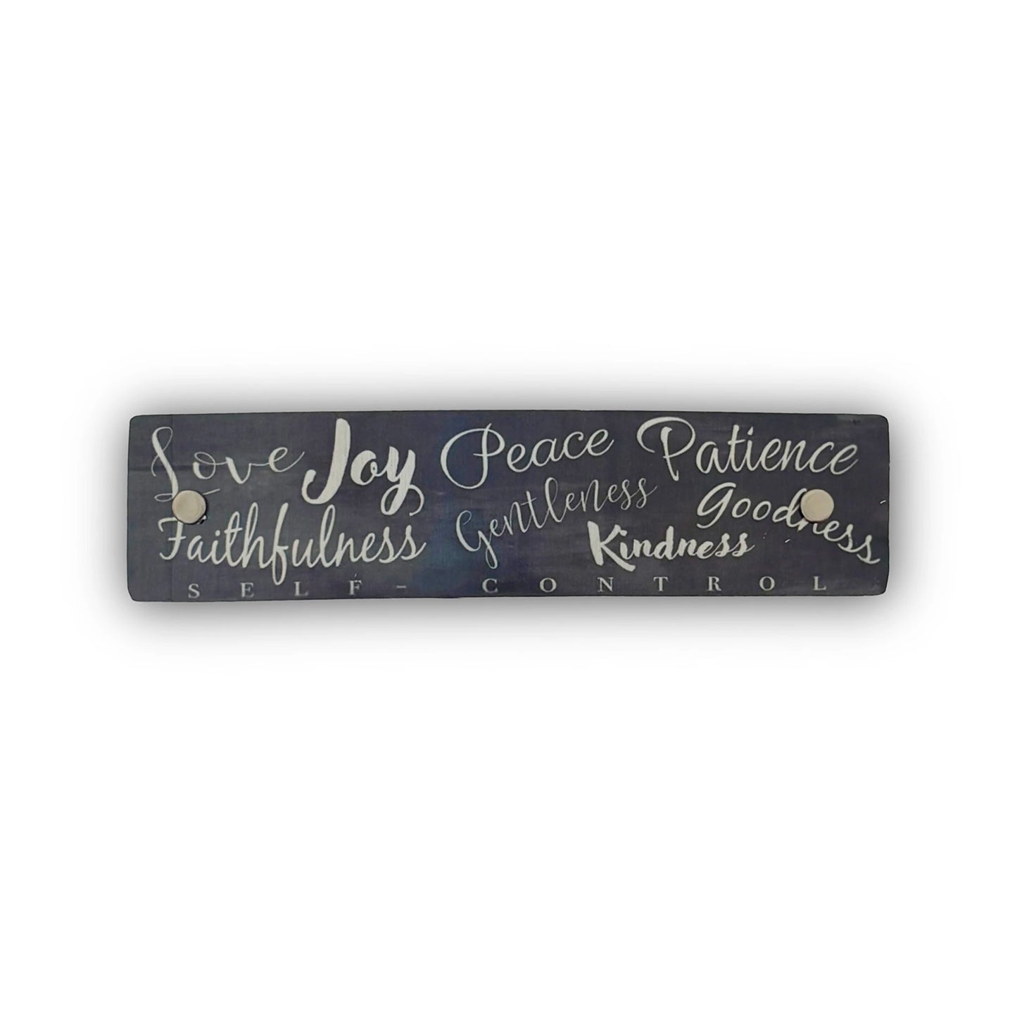 A rectangular dark gray French barrette with silver hand-lettered text listing virtues such as love, joy, peace, patience, kindness, and goodness, shown on a plain white background.