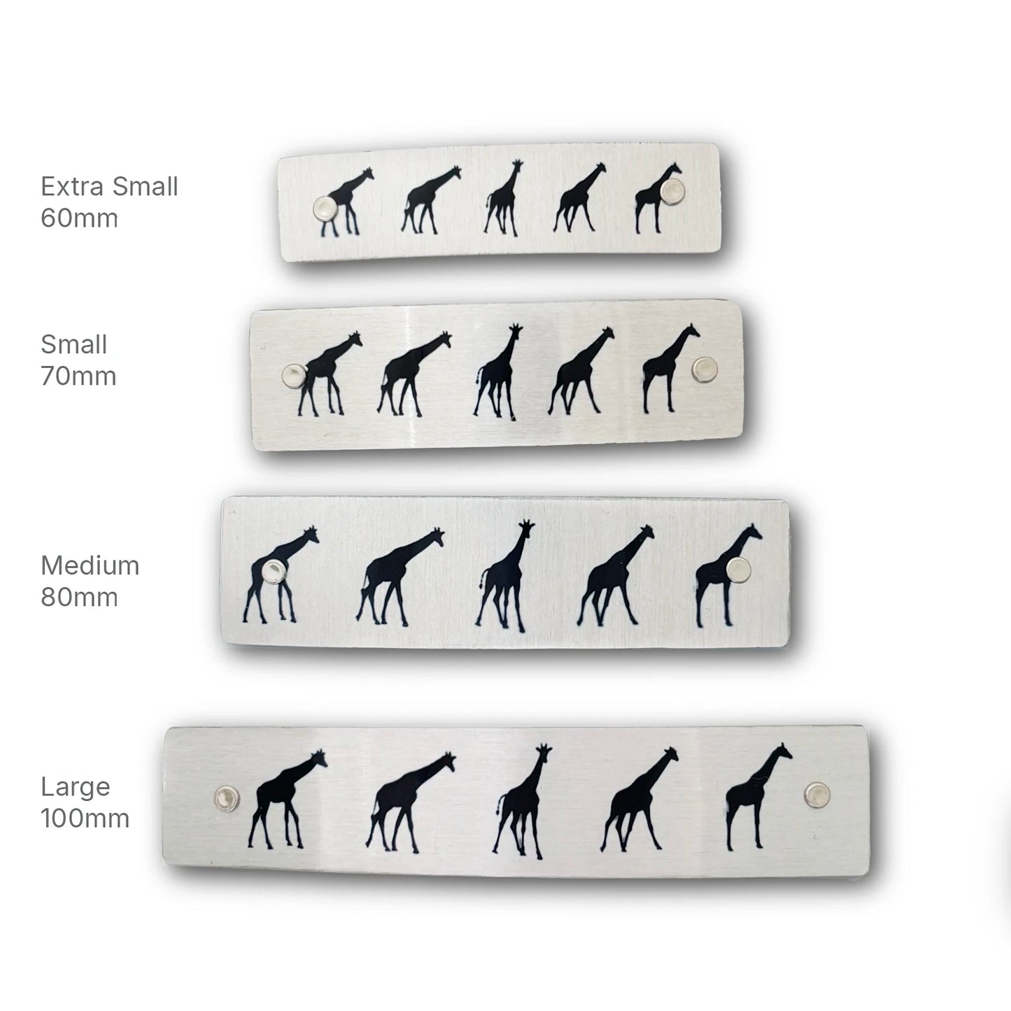 Four rectangular silver metal hair barrettes of different sizes (Extra Small 60mm, Small 70mm, Medium 80mm, Large 100mm), each featuring a black giraffe silhouette pattern, displayed against a white background with size labels.