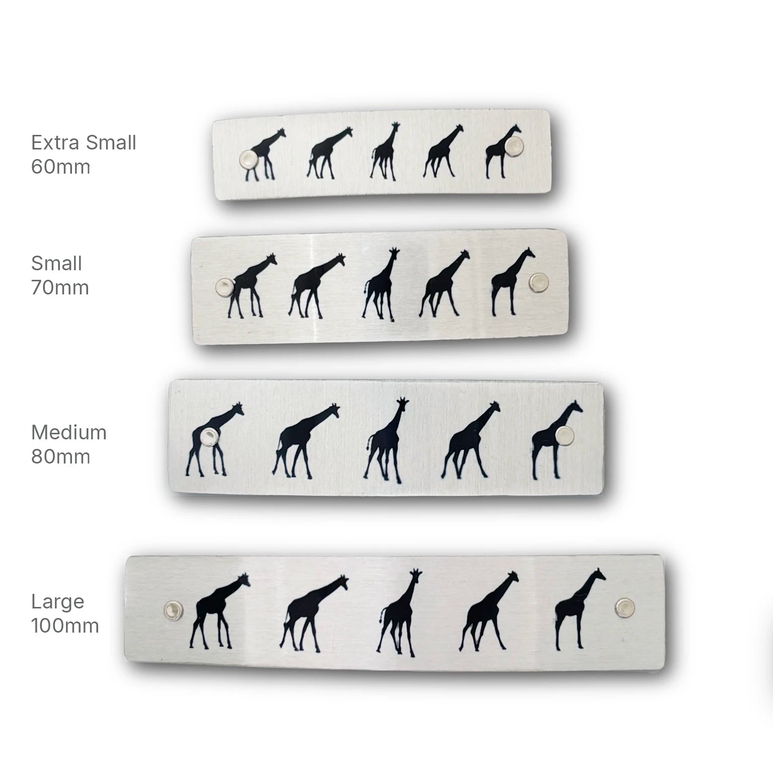 Four rectangular silver metal hair barrettes of different sizes (Extra Small 60mm, Small 70mm, Medium 80mm, Large 100mm), each featuring a black giraffe silhouette pattern, displayed against a white background with size labels.