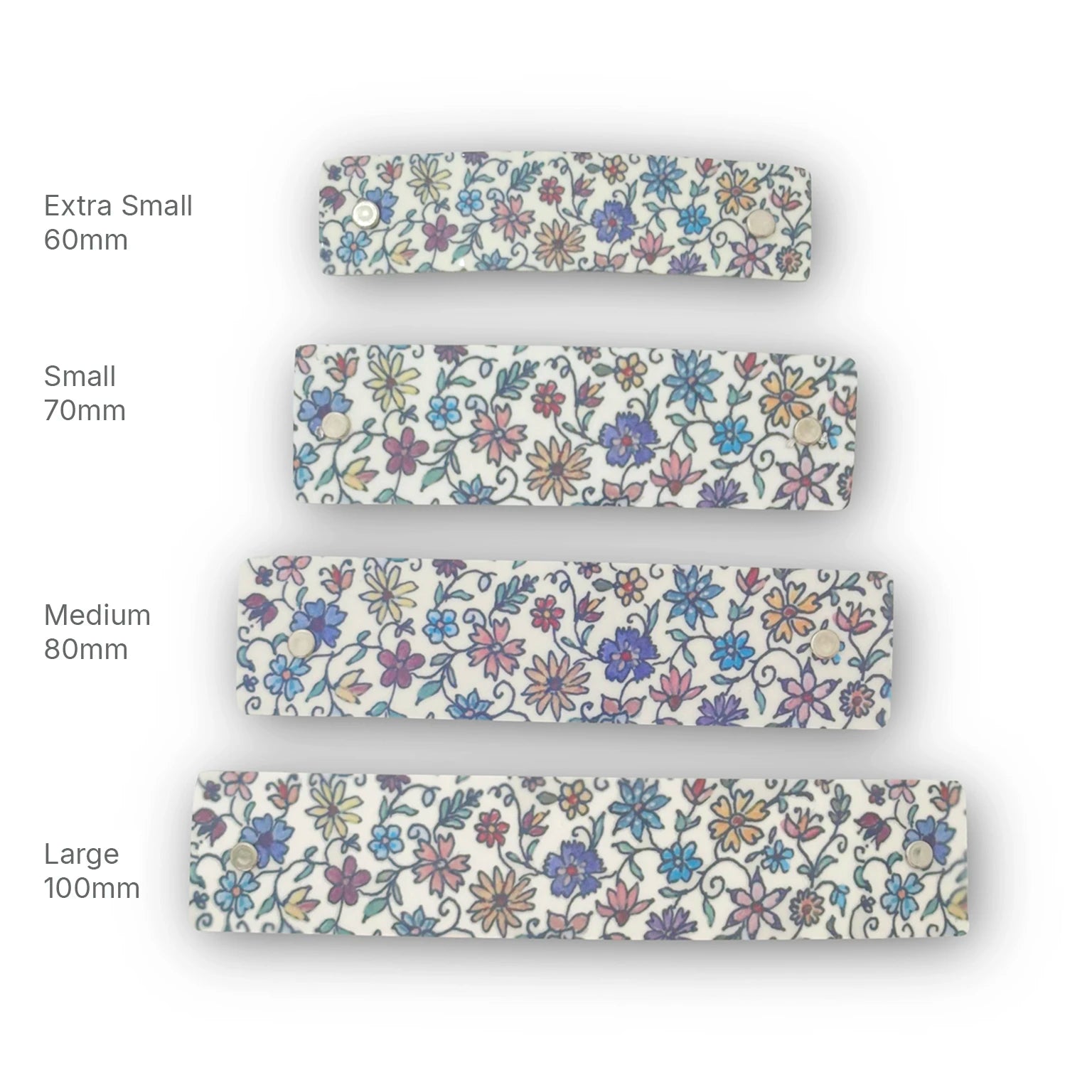 Four floral-patterned handmade metal hair clips shown in different sizes labeled Extra Small 60mm, Small 70mm, Medium 80mm, and Large 100mm on a white background.