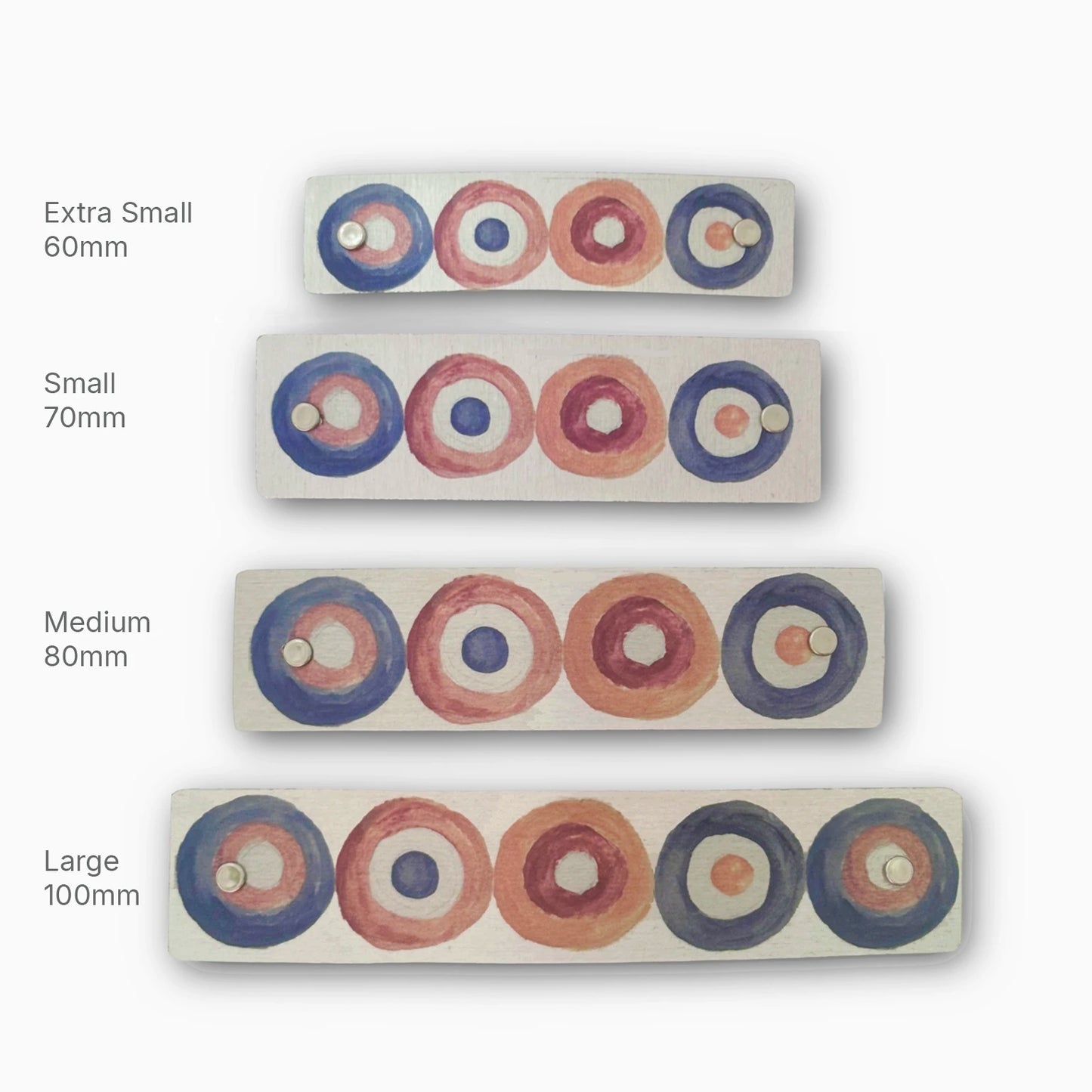 Four hair clips in sizes from extra small to large, featuring a geometric design of nested circles in earth tones.