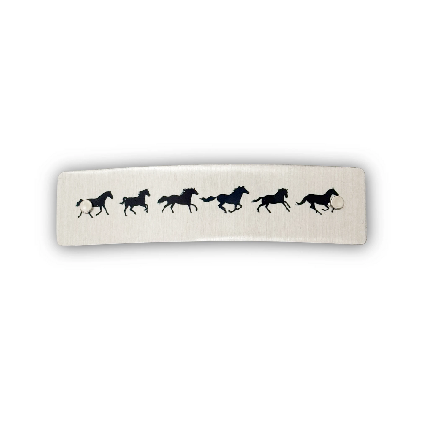 A sleek silver metal barrette featuring black galloping horse silhouettes, hand made in North Carolina by Robbin V. Davis Studio.