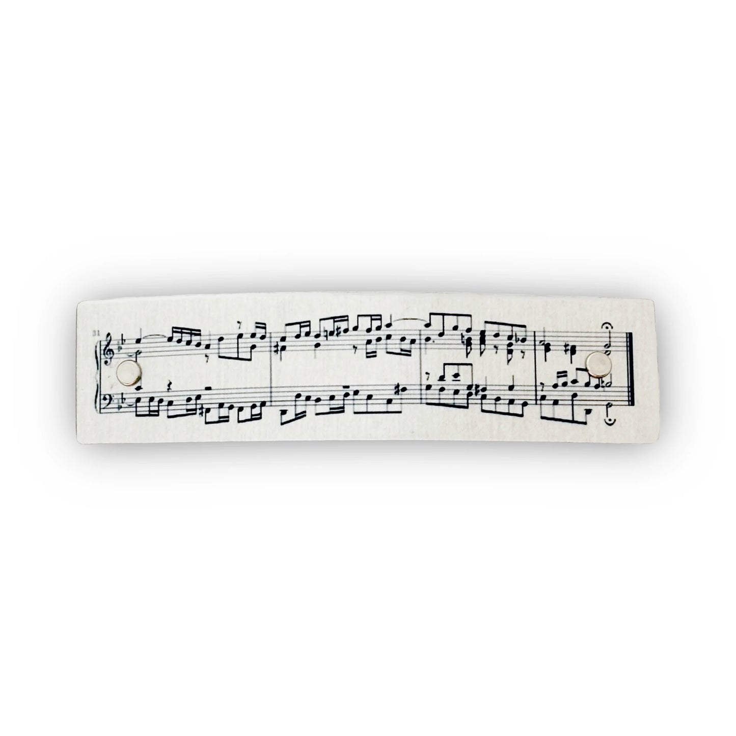 A boutique metal hair clip with printed classical music notation, shown against a plain white background.