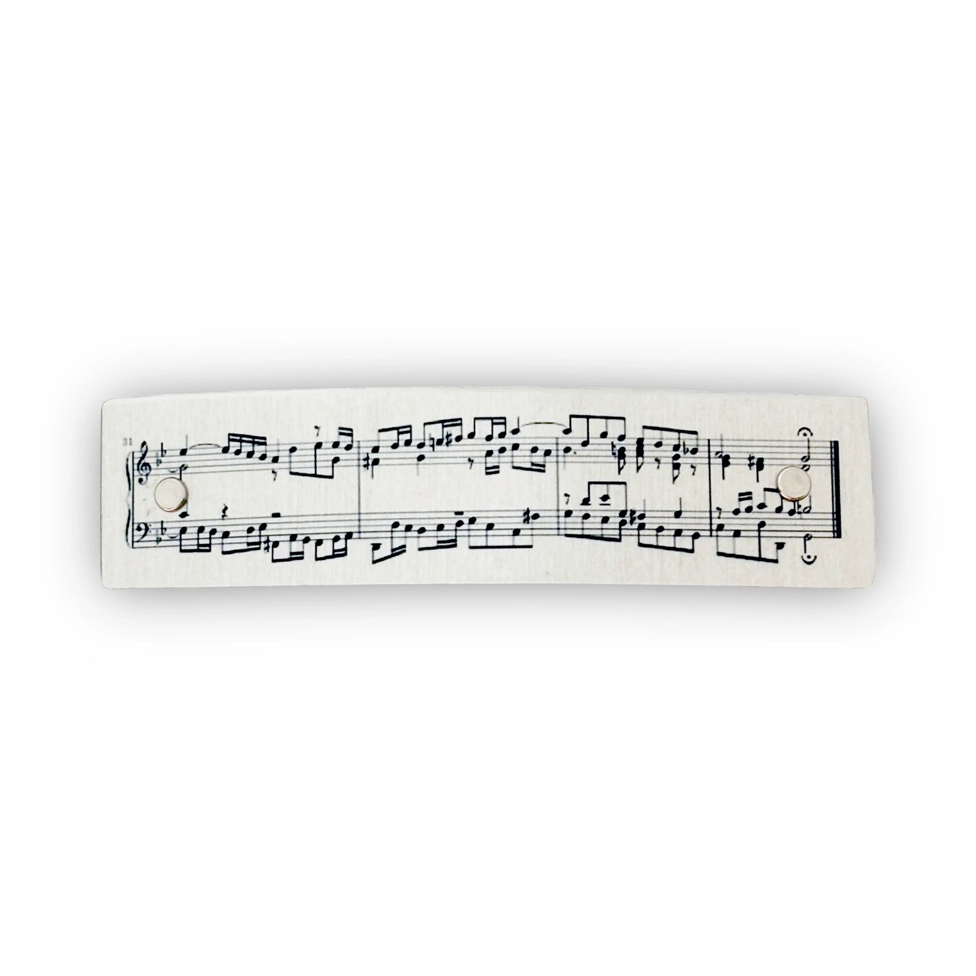 A boutique metal hair clip with printed classical music notation, shown against a plain white background.