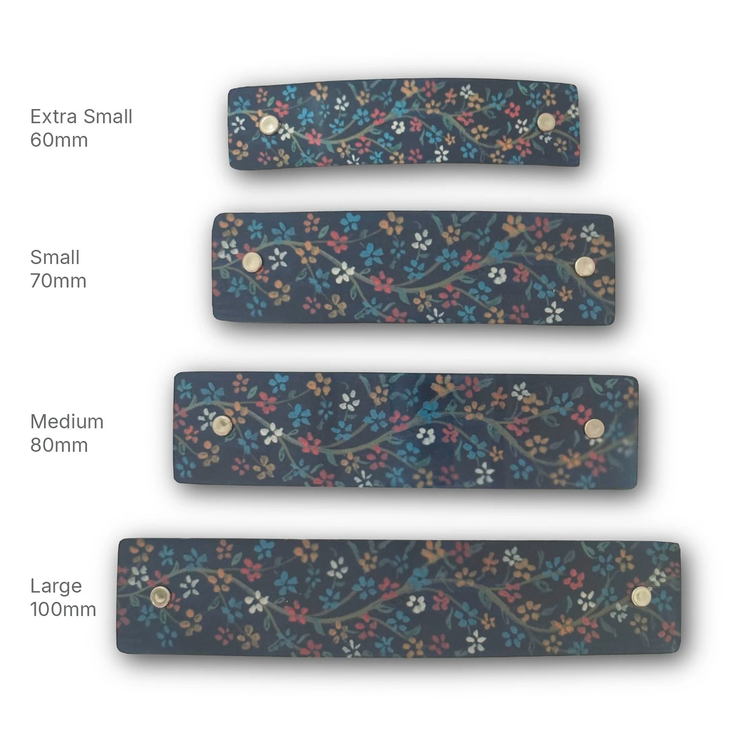 Four rectangular handmade floral-patterned metal hair clips in different sizes labeled Extra Small 60mm, Small 70mm, Medium 80mm, and Large 100mm on a white background.