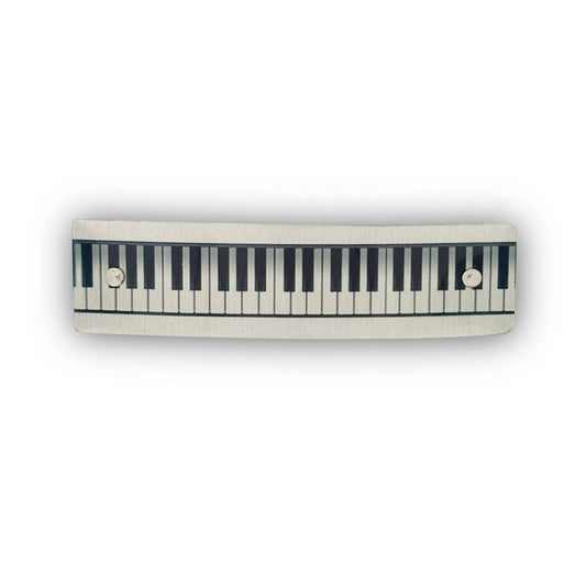 A handmade hair barrette with a piano keyboard design, by Robbin V. Davis Studio.
