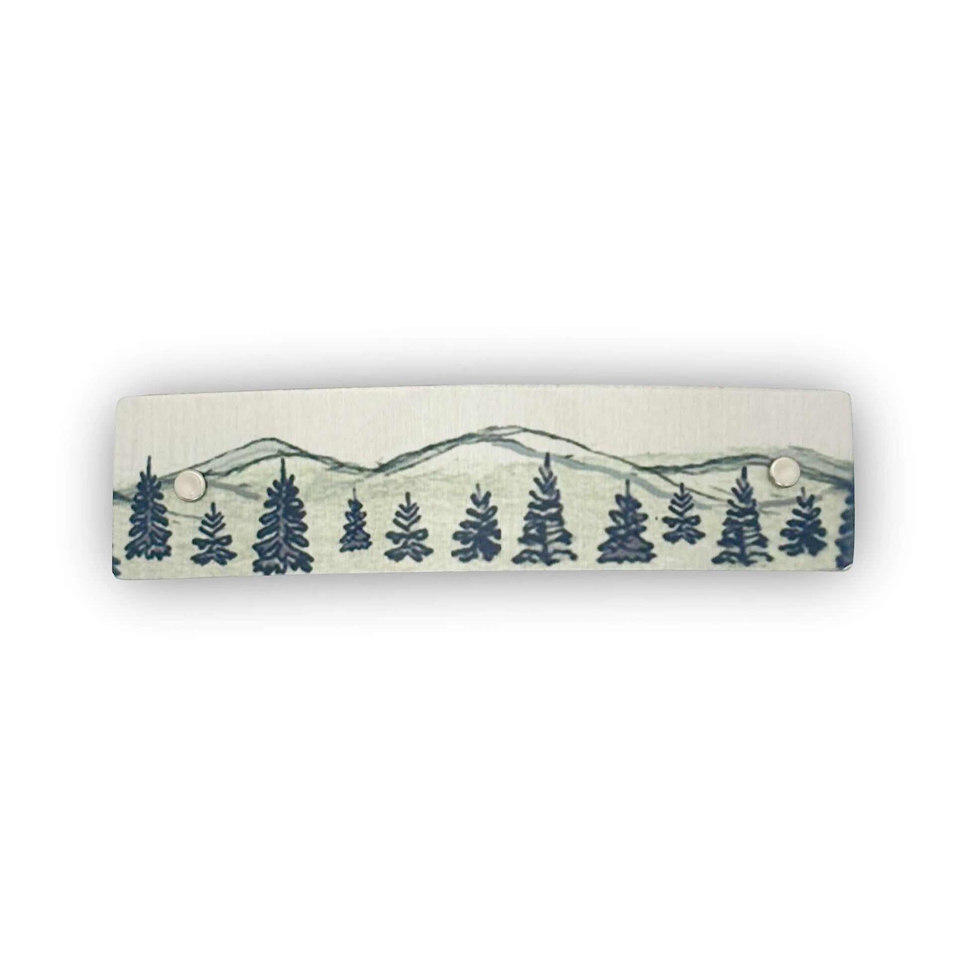 A silvery aluminum hair clip with a mountain and pine tree landscape shown on a white background.
