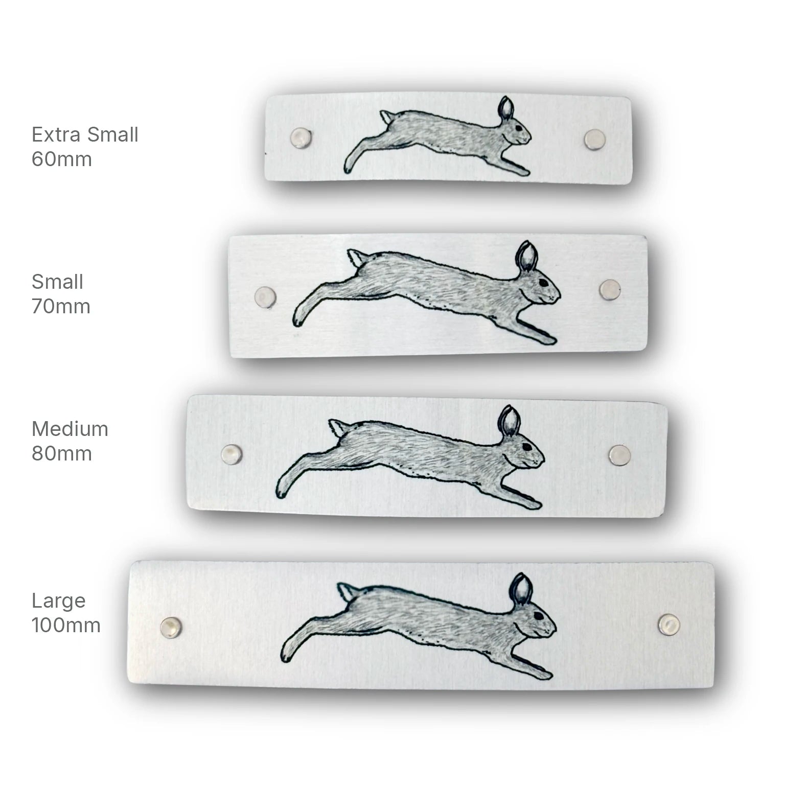 Four rectangular brushed-metal barrettes shown in different sizes labeled Extra Small 60mm, Small 70mm, Medium 80mm, and Large 100mm, decorated with original artwork of a leaping rabbit.