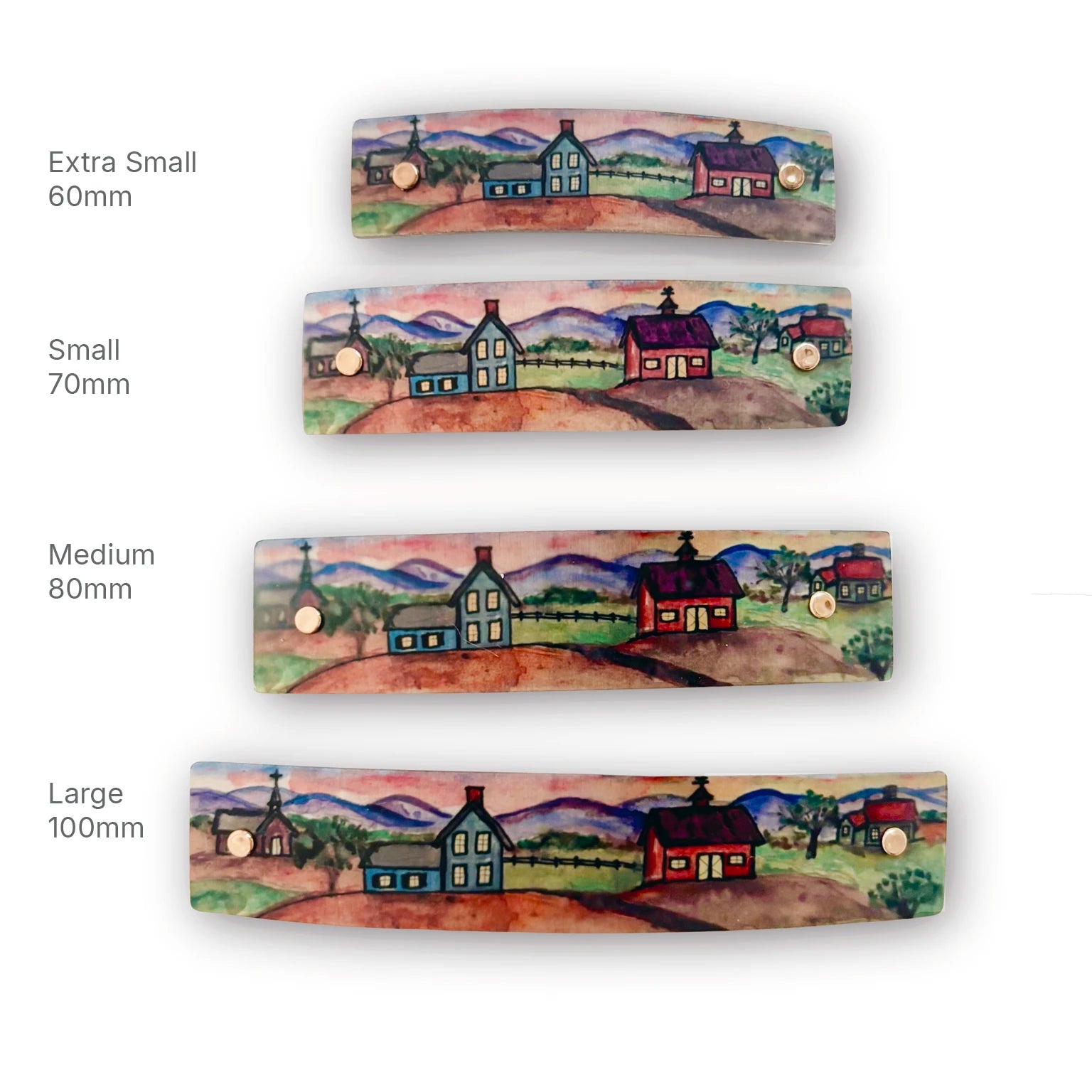 Four landscape-themed hair clips shown in different sizes (Extra Small 60mm, Small 70mm, Medium 80mm, Large 100mm) on a white background, each featuring a painted rural scene with houses, hills, and mountains.