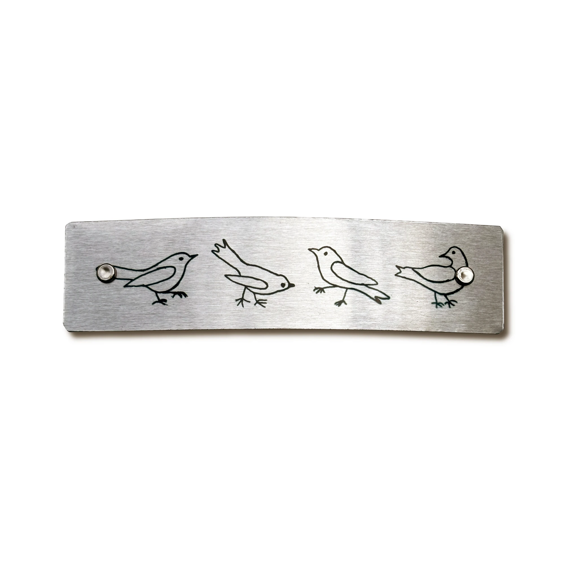 A brushed metal hair barrette  featuring four minimalist quirky bird illustrations, photographed against a clean white background.