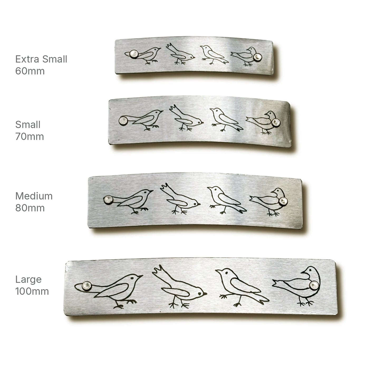 Four rectangular silver metal barrette sizes labeled Extra Small 60mm, Small 70mm, Medium 80mm, and Large 100mm, adorned with a row of small bird figures, on a white background.
