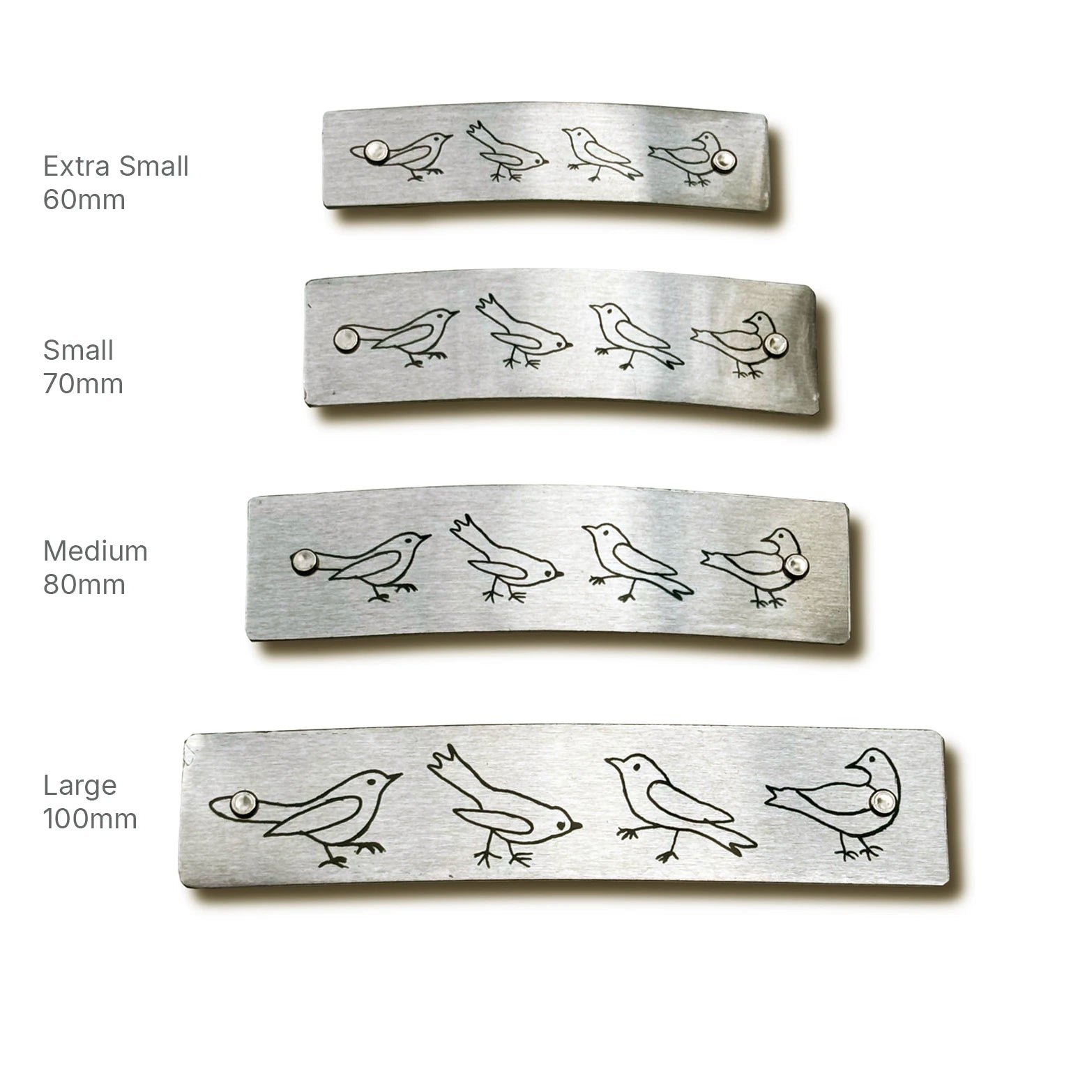 Four rectangular silver metal barrette sizes labeled Extra Small 60mm, Small 70mm, Medium 80mm, and Large 100mm, adorned with a row of small bird figures, on a white background.