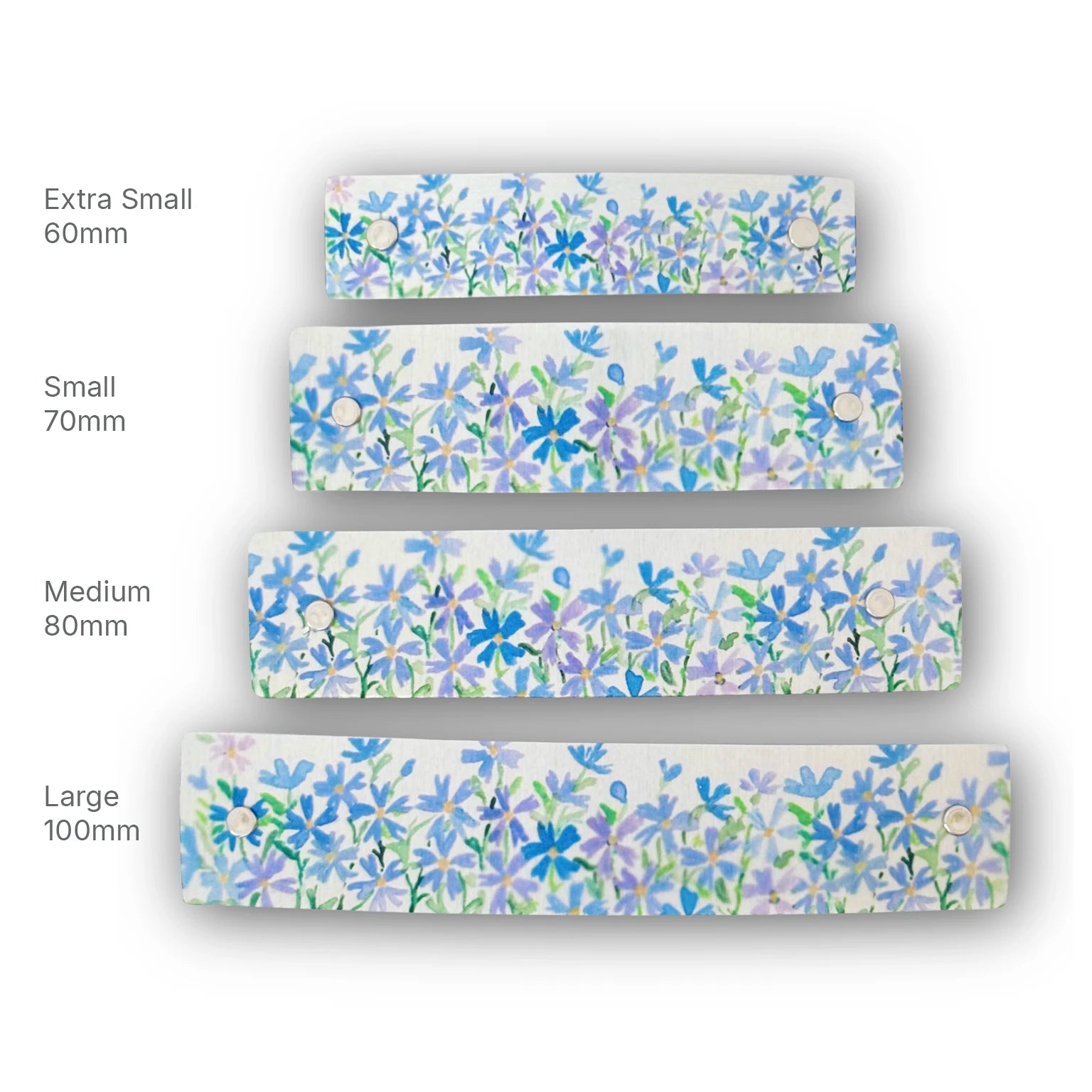 Four floral-patterned hair clips in shades of purple and blue on a silver metal background, shown in different sizes labeled Extra Small 60mm, Small 70mm, Medium 80mm, and Large 100mm on a white background.