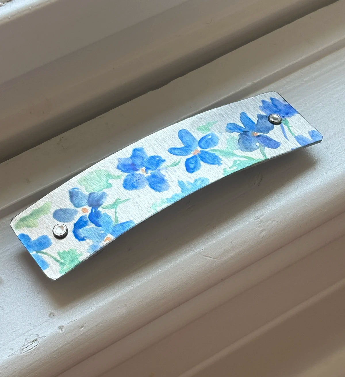 Close up of a hair barrette decorated with original watercolor artwork by Robbin V. Davis.